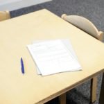 Papers with pen on table in classroom