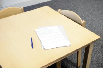Papers with pen on table in classroom
