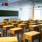 a classroom filled with lots of wooden desks